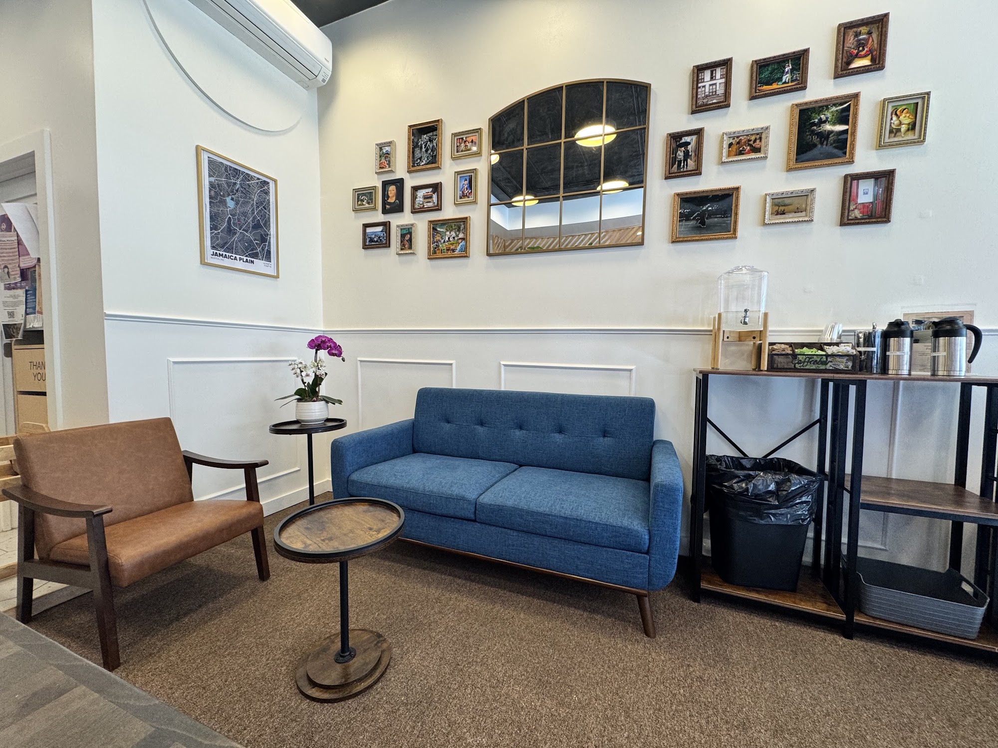 Viza Cafe seating area with blue sofa, mirror, artwork, and orchid